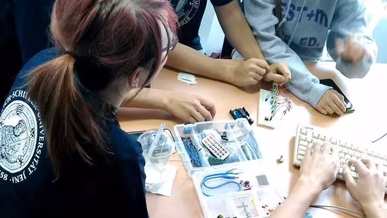 Teilnehmende beim Sommercamp wühlen in der Hardware-Kiste