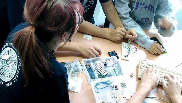 Teilnehmende beim Sommercamp wühlen in der Hardware-Kiste